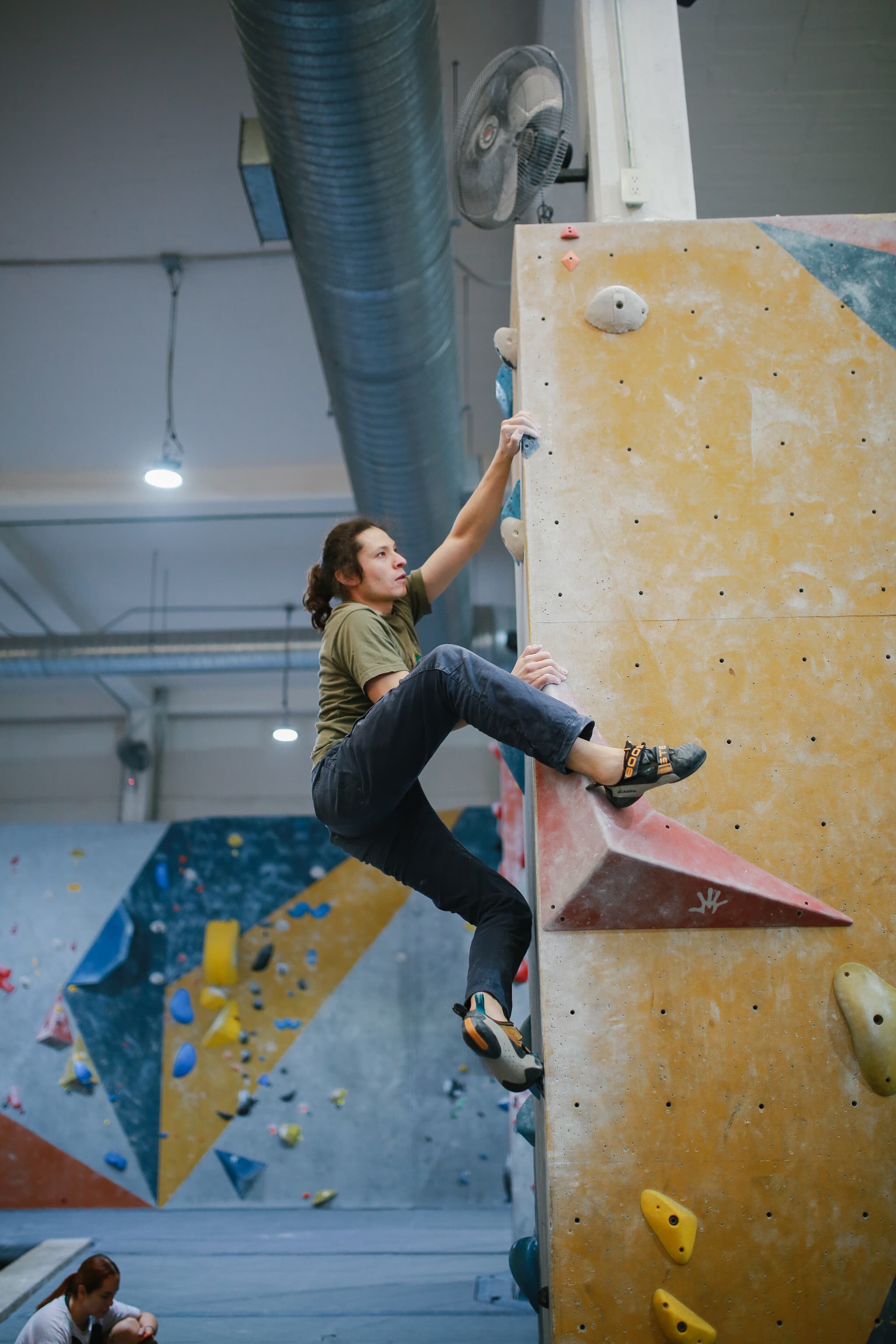 Escalador enfocado subiendo una vía de boulder